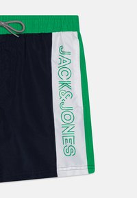 Mornarske kupaće hlače s zelenim i bijelim detaljima, s natpisom "JACK&JONES" u zelenoj boji na bijelom panelu. Elastična utezna traka s vezicom.