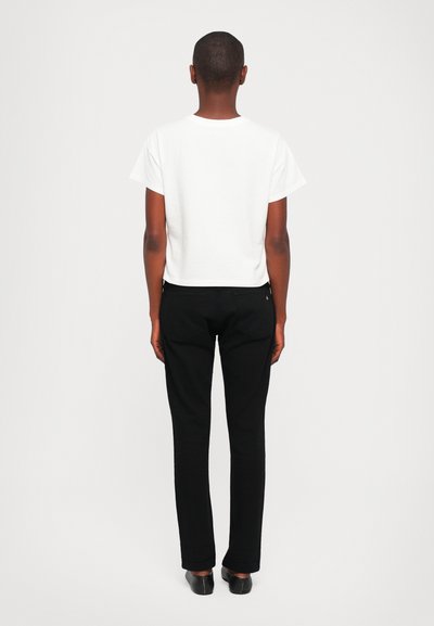 White cropped t-shirt with short sleeves paired with black slim-fit pants. The outfit features a plain design, no visible patterns or accents.