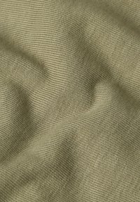 Tessuto khaki texturizzato con un sottile motivo a spina di pesce, morbido al tatto con un leggero lucido, che mette in mostra i fili intrecciati.