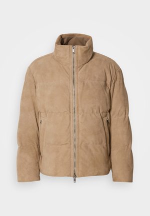 Chaqueta de cuero beige con un cuello alto, textura suave y cremallera en la parte delantera. Cuenta con bolsillos laterales y un diseño acolchado para el aislamiento.