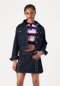 Tume teksast jope hõbedaste nööpidega ja kahe rinnataskuga, koos triibulise ribi crop topi ja pitsiga külgedel denim seeliku täiendusega.