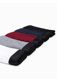 Šest párů srolovaných ponožek v bílé, šedé, burgundské, námořnické, černé a tmavě šedé barvě, každé s kontrastním černým lemem.