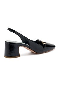 Scarpa slingback in vernice nera con punta affusolata, tacco a blocco di altezza media e un'accento decorativo a forma di fibbia sulla fascetta.