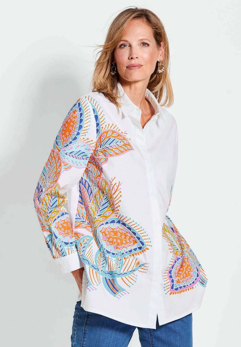 Witte overhem shirt met kleurrijke bloemmotieven in oranje, blauw en groen op de mouwen. Gladde textuur, relaxte pasvorm, kraagontwerp.