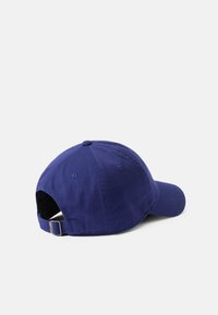 Gorra de béisbol azul hecha de tela, con visera curva, tira ajustable en la parte trasera y detalles cosidos en la corona.