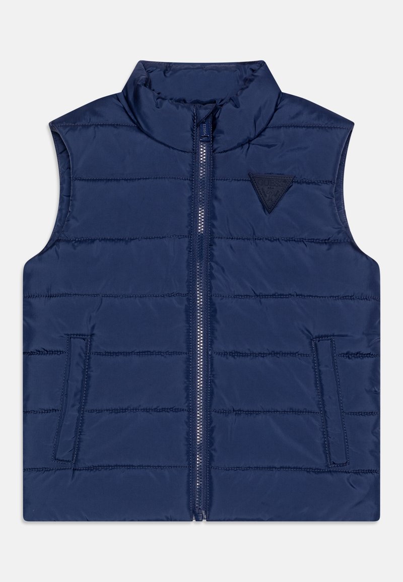 Vest puffer de culoare bleumarin, cu guler înalt, închidere cu fermoar, quiltare orizontală subtilă și o etichetă triunghiulară pe pieptul stâng.