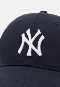 Casquette de baseball navy avec logo "NY" brodé en blanc, dotée d'une couronne structurée, d'une texture de tissu lisse et d'une visière incurvée.