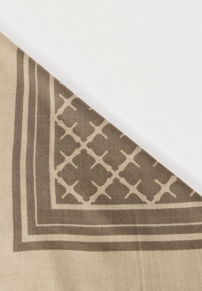 Μπεζ κασκόλ με γεωμετρικό καφέ μοτίβο και διακοσμητικό περίγραμμα. Το ύφασμα είναι απαλό, με λεία υφή και ελαφριά αίσθηση.