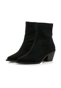 Par de botas de tobillo de ante negro con punteras puntiagudas y tacones bajos en un fondo blanco.