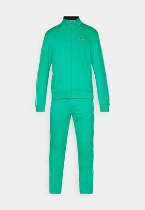 Zeleni trenirka iz mehkega materiala. Zip-up jakna ima visok ovratnik, kontrastne stranske črte in logo na prsih.