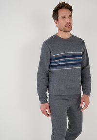 Sudadera gris con un diseño de rayas horizontales en azul, verde azulado y blanco. Hecha de un tejido suave, con cuello redondo y puños acanalados.