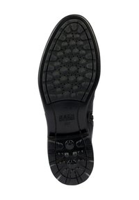 Suola di scarpa in gomma nera con modelli di trazione testurizzati, disegni circolari e a forma di stella, marchiata con "GEOX" e "ULTRA COMFORT."