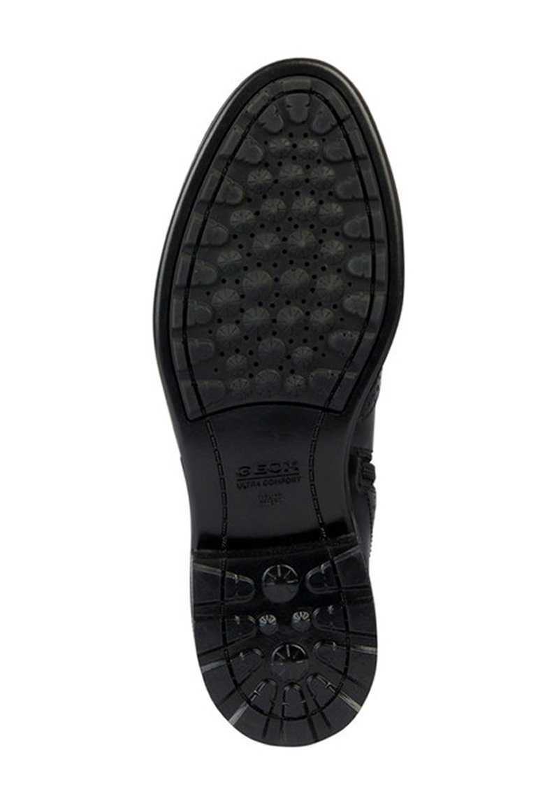 Schwarze Gummischuhsohle mit strukturierten Traktionsmustern, kreisförmigen und sternförmigen Designs, gebrandet mit "GEOX" und "ULTRA COMFORT."