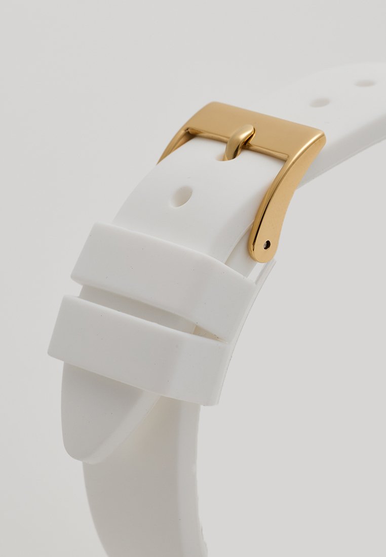 Correa de reloj de silicona blanca con hebilla de metal en tono dorado. Presenta una textura suave y dos franjas horizontales para mayor interés visual.