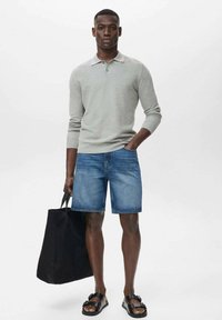 Light grey long-sleeve polo, blue denim shorts, black tote bag, and brown sandals with buckles. Simple design with a relaxed fit.