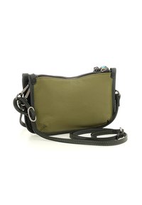 Piccola borsa a tracolla in pelle verde oliva con bordi neri, zip argentata e tracolla regolabile arrotolata accanto su uno sfondo bianco.