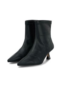 Par de botas de cuero negro hasta el tobillo con punteras en punta y tacones bajos de gato, mostradas sobre un fondo blanco.