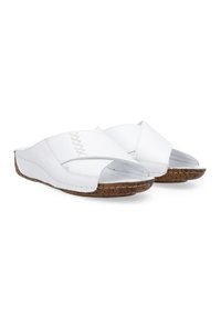 Weiße Slipper-Sandalen mit offener Zehenpartie und überkreuzten Riemen. Kork-texturierte Sohle mit genähten Akzenten entlang der Kanten. Glatte Lederoberfläche.