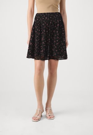 Falda negra con estampado floral, cintura fruncida, con pequeñas flores rosas y blancas. Tela ligera y fluida, diseño hasta la rodilla.