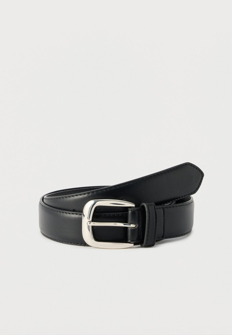 Ceinture en cuir noir avec boucle rectangulaire en argent, enroulée et posée sur une surface blanche.