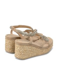 Sandali con zeppa beige con una piattaforma in corda intrecciata, caratterizzati da più cinturini adornati con cristalli decorativi.