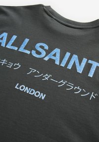 Juodas marškinėlis su ryškiu mėlynu tekstu "ALLSAINT" ir "LONDON", taip pat su papildomu tekstu japonų kalba. Pagamintas iš medvilnės, su apvaliu kaklu.