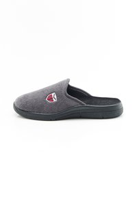 Pantofole slip-on in corduroy grigio con suola nera e emblema a scudo rosso e bianco sulla parte superiore, isolate su sfondo bianco.