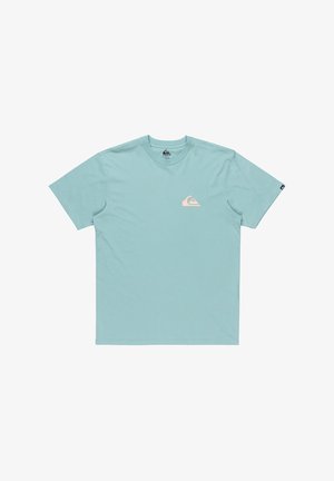 Ljusblå bomullströja med rund halskrage och korta ärmar. Har en rosa logotyp på vänster bröst och en svart etikett på ärmen.