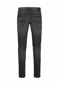 Jeans skinny negros descoloridos con una textura suave, que cuentan con dos bolsillos traseros y una etiqueta de piel en la cinturilla. Diseño simple y ajustado.