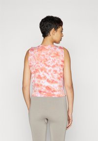 Sleeveless crop top in pink and orange tie-dye pattern, made of soft fabric with a smooth texture. Straight hem and simple design.