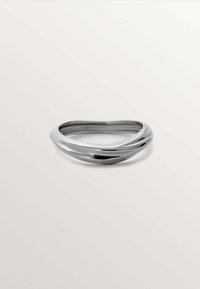 Anillo de plata retorcido con una superficie lisa y reflectante. Presenta bordes redondeados y un diseño minimalista, ligeramente asimétrico en forma.