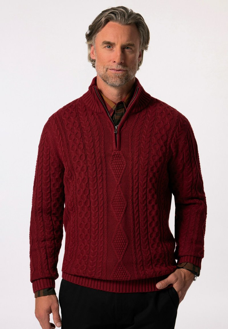 Burgundy stickad tröja med kabelstickad design, halvdragkedja i kragen, ribbade muddar och nederkant, bärs över en rutmönstrad skjorta. Texturerad detalj genom hela tröjan.