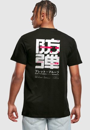 Camiseta de algodón negra con grandes gráficos impresos en blanco y rosa en la parte posterior, exhibiendo texto estilizado y acentos decorativos.