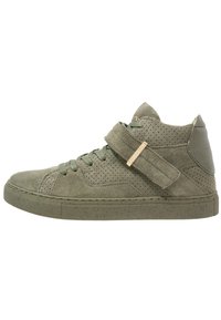 Zapatilla alta de ante verde con detalles perforados, parte delantera con cordones, una correa de Velcro y suela de goma moteada.