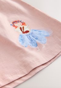 Rožnata bombažna tkanina z ilustracijo deklice v svetlo modri tila krilu, ki drži rjavega zajčka, z rožnatimi dodatki v laseh.