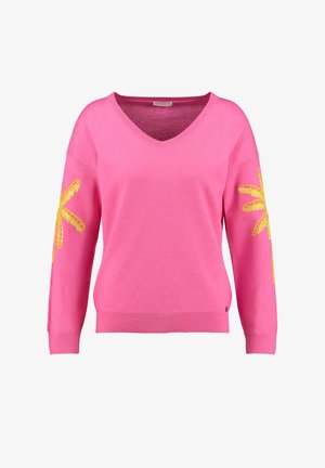 Jasnoróżowy sweter z dekoltem w kształcie litery V, długimi rękawami i żółtymi kwiatowymi zdobieniami na obu rękawach. Miękka dzianina z prążkowanym wykończeniem na dole.