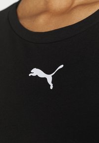 Czarna bawełniana koszulka z białym logo Pumy na lewej piersi, okrągły dekolt i gładka tekstura.