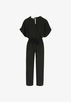 Mustast lühikeste varrukatega kombinesoon, millel on ümbermähitav eesmine osa, vöökohal pael ja sirged püksisääred, valgel taustal.