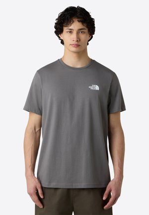 Grijze katoenen t-shirt met korte mouwen, ronde hals, met een wit logo op de linkerborst en een gladde, zachte textuur.