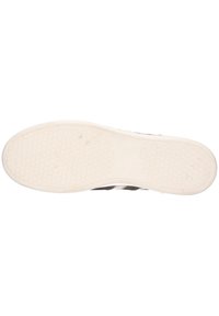 Schwarz-weiße Sneaker mit einer strukturierten Gummisohle, runder Zehenform und seitlichen Streifen. Die Sohle hat ein Wabenmuster für optimalen Halt.