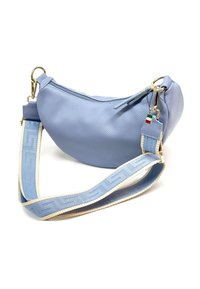 Blauwe leren tas met een gebogen vorm. Heeft een gestreepte schouderband, gouden hardware en een label met een Italiaanse vlag. Ritsafsluiting.