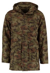 Maskovací parka v olivově zelené barv ě s hnědými akcenty. Obsahuje kapuci, čtyři kapsy a zapínání na knoflíky. Odolná tkanina s texturovaným povrchem.