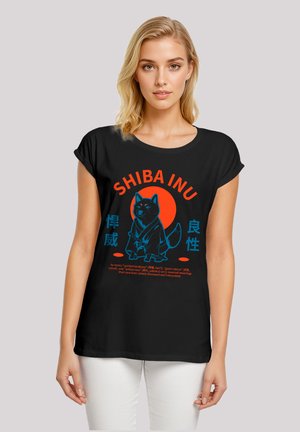 Schwarzes T-Shirt mit einem Shiba Inu Grafik in Blau, mit roten Akzenten und Text. Das Design zeigt einen stilisierten Hund vor einem kreisförmigen Hintergrund.