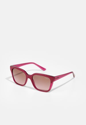 Sunglasses with a rectangular frame, made of transparent pink plastic with a glittery finish, brown gradient lenses, and sleek arms.