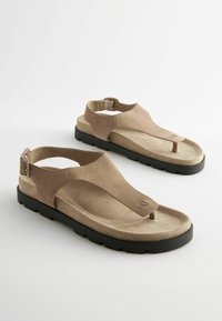 Bruine suède sandalen met een teenslipperontwerp, verstelbare hakband en zwarte rubberen buitenzool. Soepele textuur en gevormde voetbed.