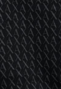 Tecido preto com um padrão geométrico repetido das letras "A" e "X" numa tonalidade mais escura, criando uma textura subtil.