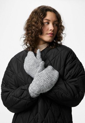 Szare, dzianinowe rękawiczki o miękkim, teksturowanym wykończeniu, w połączeniu z czarną pikowaną kurtką. Rękawiczki są oversize i bardzo przytulne.