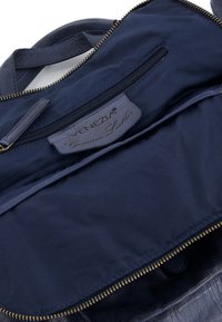 Granatowa torebka skórzana z prawdziwej skóry, wnętrze z zamykaną na zamek kieszonką oraz podszewką z tkaniny. Zawiera metkę z napisem "VENEZIA Genuine Leather."