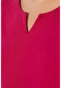 Top fucsia con scollatura a V, realizzato in tessuto morbido con una texture liscia e dettagli delle cuciture sottili.