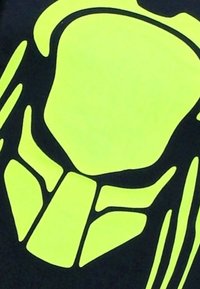 Zwarte stof met een groot, abstract ontwerp in fel neon geel, met hoekige vormen en contouren die een opvallend visueel contrast creëren.